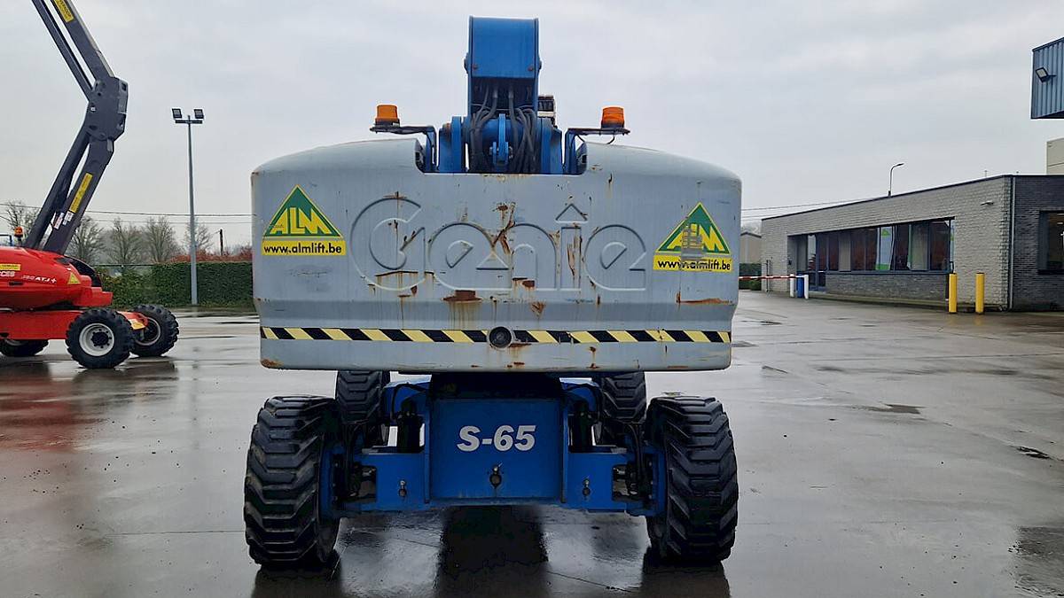L'arrière d'une Genie S-65 4WD, qui ressemble à une nacelle élévatrice jeune et usagée.
