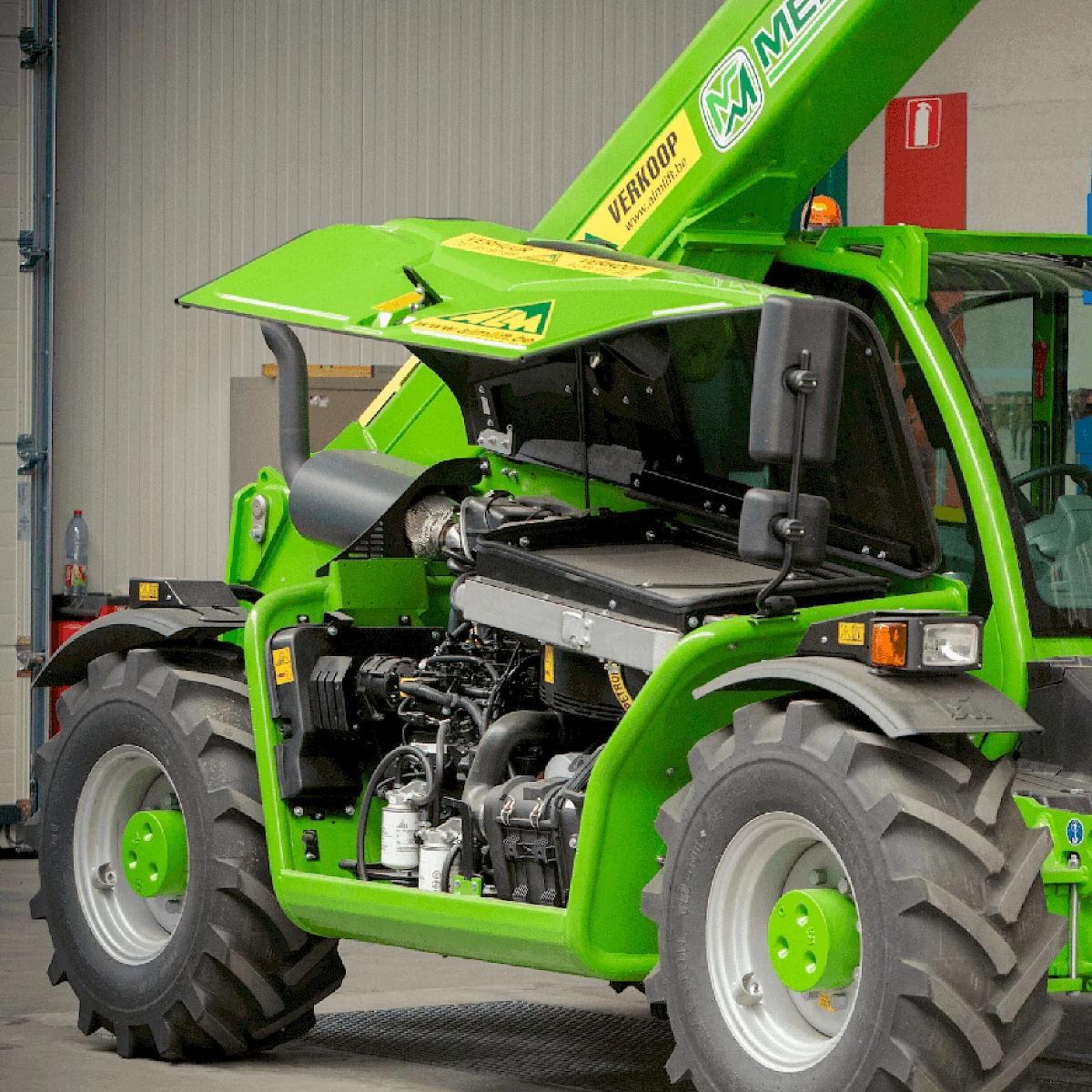 Groene hoogwerker met de kap open toont de goed onderhouden motor